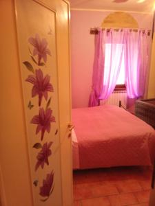 スポレートにあるDimora Spoletina Iのベッドルーム1室(ピンクの花が咲くドア付)