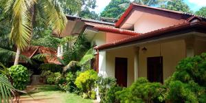 a house with a garden in front of it at Wild View Stay in Habarana