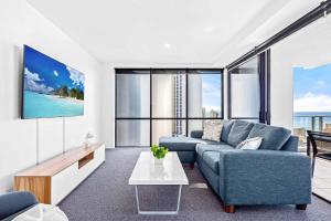 a living room with a blue couch and a tv at Holiday Holiday Circle On Cavill Apartments in Gold Coast +18 photos