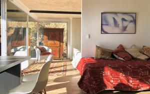 Schlafzimmer mit einem Bett, einem Tisch und Stühlen in der Unterkunft Lofts Casa El Pangue Zapallar in Zapallar