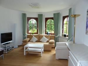 a living room with a couch and a tv at Schwarzwaldturmzimmer Lahr in Lahr
