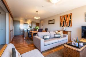 a living room with a couch and a table at The Sands - Apartment 12 - Stay Waiheke in Onetangi +10 photos