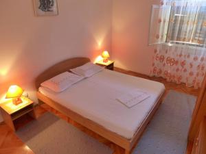 um quarto com uma cama com dois candeeiros em duas mesas em Apartment Mari - 30 m from sea em Sumartin
