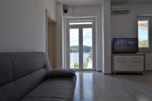 uma sala de estar com um sofá e uma televisão em Apartment Mari - 30 m from sea em Sumartin