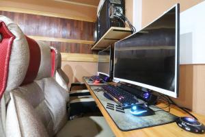 a desk with a computer monitor and a keyboard and mouse at Hotel Don in Changwon