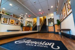 a lobby of a hotel with a staircase and a rug at The Steveston Cafe & Hotel in Richmond