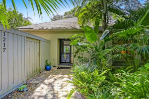 a small yellow house with a door and some plants at 1217 Lagoon Villas in Fernandina Beach