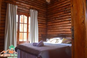 a bedroom with a bed in a log cabin at Monte Sion cabañas & relax in San Javier
