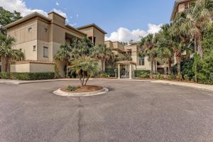 a building with a palm tree in the middle of a street at 2533 Tennis Villas Efficiency in Fernandina Beach