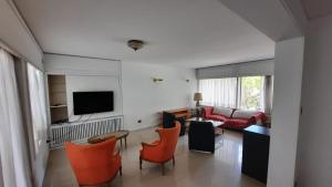 sala de estar con sillas de color naranja y sofá en Casa Villa Nueva en Mendoza