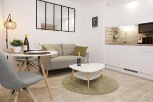 a living room with a couch and a table at Cocon Cosy Flat - Hyper-Centre Senlis in Senlis