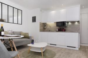 een keuken en een woonkamer met een bank en een tafel bij Cocon Cosy Flat - Hyper-Centre Senlis in Senlis