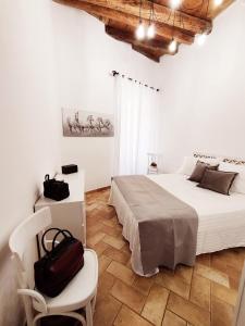 una camera bianca con un letto e una sedia di Holiday Home Virgilio House a Cagliari