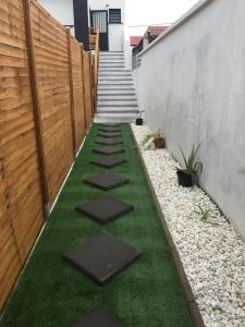 a walkway with grass and rocks next to a fence at Cocon De L'Est I in Saint-Benoît