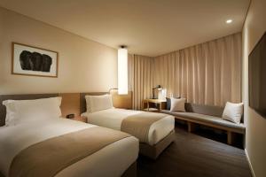 a hotel room with two beds and a couch at Shilla Stay Samsung COEX Center in Seoul