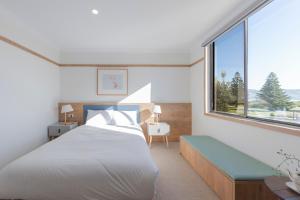 een slaapkamer met een bed en een groot raam bij Blue Ocean Motel Apollo Bay in Apollo Bay