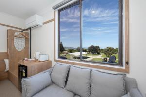 ein Wohnzimmer mit einem Sofa und einem großen Fenster in der Unterkunft Blue Ocean Motel Apollo Bay in Apollo Bay