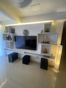 uma sala de estar com uma grande televisão de ecrã plano em GUARAJUBA Condomínio PARAÍSO DOS CORAIS BEACH RESORT 132 em Guarajuba