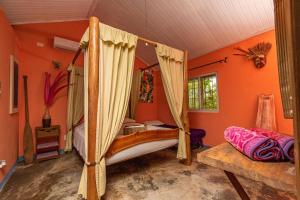 a bedroom with a canopy bed and orange walls at Monkey Lodge Panama in Chilibre +37 photos