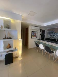 a kitchen with a counter and chairs in a room at GUARAJUBA Condomínio PARAÍSO DOS CORAIS BEACH RESORT 132 in Guarajuba