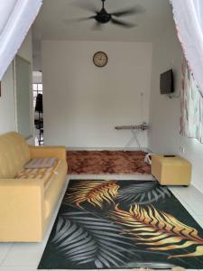 a living room with a couch and a zebra rug at Homestay De'69 in Jitra