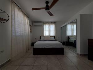 a bedroom with a bed and a ceiling fan at Aguadilla Sunset Apt AC WiFi 8 minute walk Crashboat Beach in Aguadilla