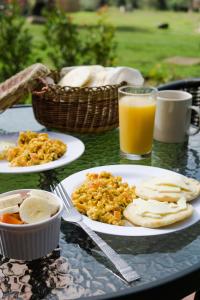 a table with plates of food and a glass of orange juice at Habitación Ancestral Sol Muisca in Villa de Leyva