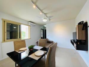 a dining room with a black table and chairs at Apartamento Canabarro Residence in Uruguaiana