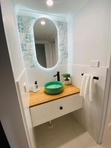 La salle de bains est pourvue d'un lavabo vert et d'un miroir. dans l'établissement Nuts About the Bay, à Nelson Bay