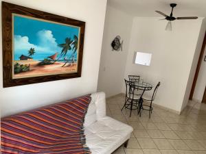 a living room with a white couch and a table at Apartamento Enseada in Guarujá +24 photos