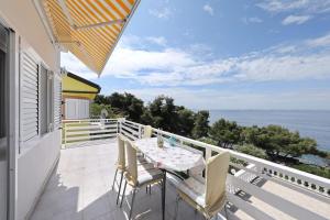 d'un balcon avec une table et des chaises donnant sur l'océan. dans l'établissement Apartments Djurdja - 20 m from beach, à Murter