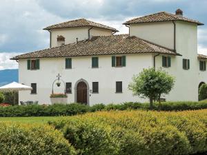 a large white house with a roof at Belvilla by OYO Villa Terra in Reggello +32 photos