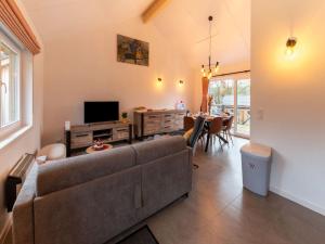 een woonkamer met een bank en een eetkamer bij Cosy chalet near Durbuy in nature in Somme-Leuze