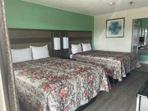 a hotel room with two beds in a room at Executive Inn & Suites in Beaumont