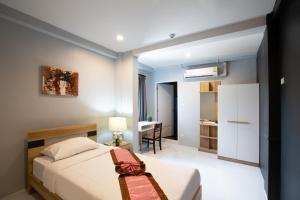 un dormitorio con una cama y un escritorio en 185@Surawong Residence, en Bangkok