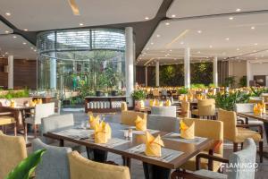 ein Restaurant mit Tischen und Stühlen in einem Gebäude in der Unterkunft FLAMINGOS DAI LAI RESORT - luxury in Ngọc Quang