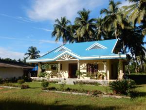 una casa con tetto blu e palme di Blue Oasis a Mangalore