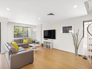 - un salon avec un canapé et une télévision dans l'établissement Yacaaba Terrace 9 3 Yacaaba Street, à Nelson Bay