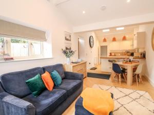uma sala de estar com um sofá e uma cozinha em The Pinfold em Melton Mowbray