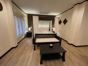 Sala de estar con cama y mesa en Na Mantra Resort en Chiang Mai