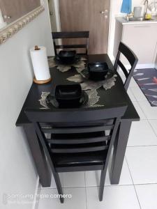 ein Tisch mit zwei Stühlen und einem schwarzen Tisch mit Stühlen sidx sidx sidx in der Unterkunft MEDINA's 5STAR CondoSTAY in Nilai in Nilai