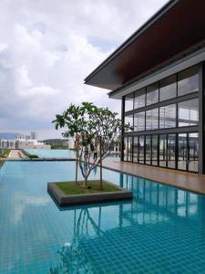a pool with a tree in the middle of a building at MEDINA's 5STAR CondoSTAY in Nilai in Nilai