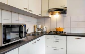 een keuken met witte kasten en een magnetron bij Beautiful Home In Delden With Sauna in Delden