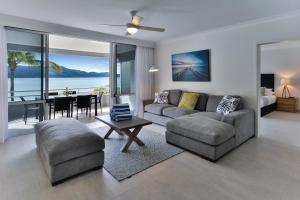 ein Wohnzimmer mit einem Sofa und einem Tisch in der Unterkunft Frangipani Apartments on Hamilton Island by HIHA in Hamilton Island