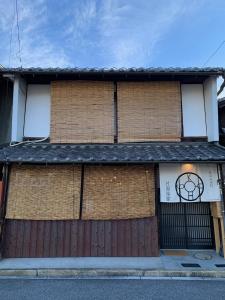 un bâtiment en briques avec un portail et une clôture dans l'établissement 長濱元浜町宿場　片原楽家, à Nagahama