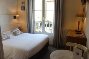 a hotel room with a bed and a window at Hotel Des Falaises in Villers-sur-Mer