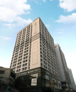 ein hohes Gebäude mit einem Schild an der Vorderseite in der Unterkunft Intrada Icheon Hotel in Icheon