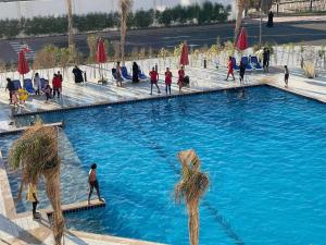 un grupo de personas caminando alrededor de una piscina en Porto Said luxury hotel rentals, en `Ezbet Shalabi el-Rûdi