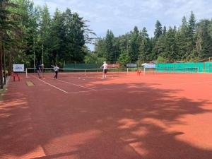 a group of people playing tennis on a tennis court at PM Services Sequoia Apartment in Borovets