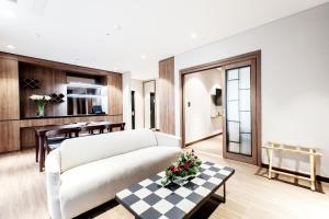 ein Wohnzimmer mit einem weißen Sofa und einem Tisch in der Unterkunft Intrada Icheon Hotel in Icheon